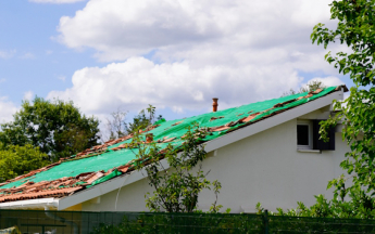 Toit endommagé par le vent sous orage.